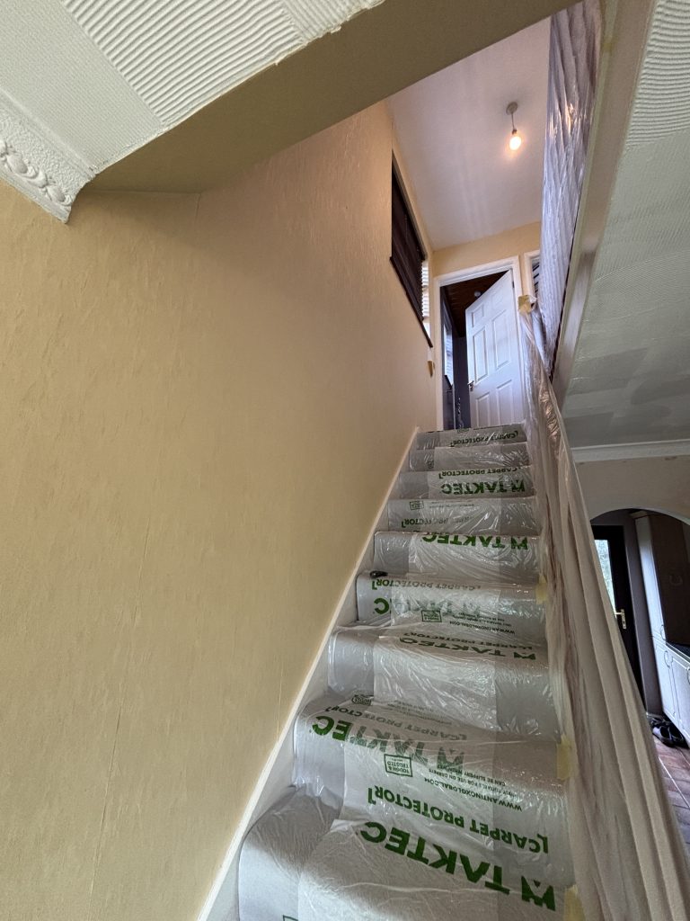 Staircase and hallway before wallpaper removal and painting in Southampton