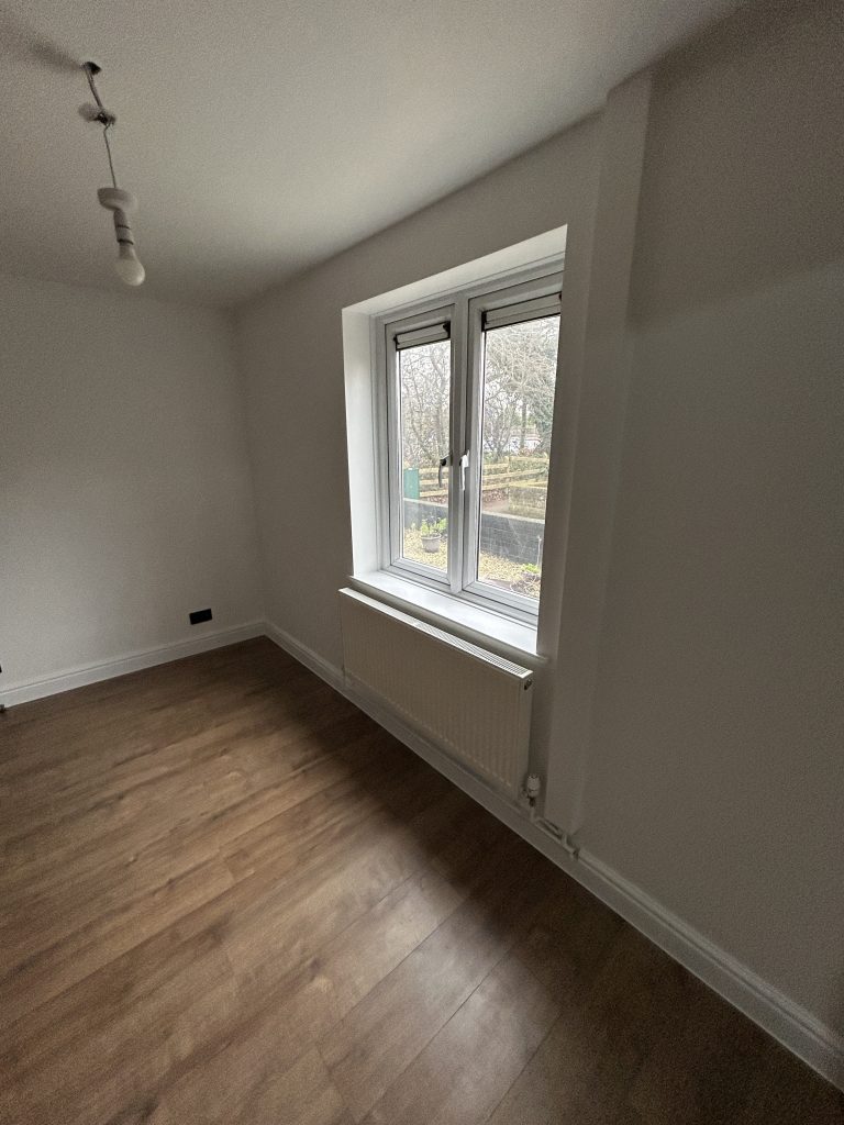 Completed living room wall and window finish in Southampton with white paint and clean renovation details.