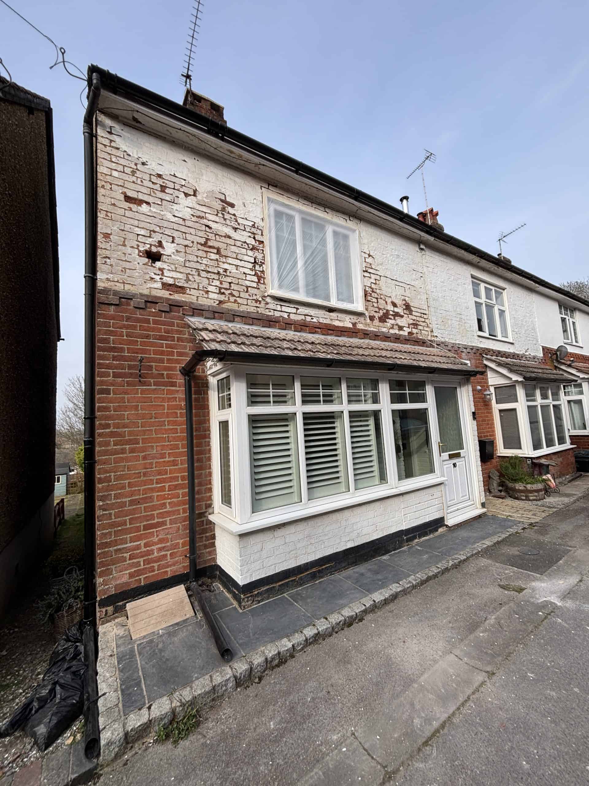 Exterior house before painting in Southampton with worn masonry and old paint