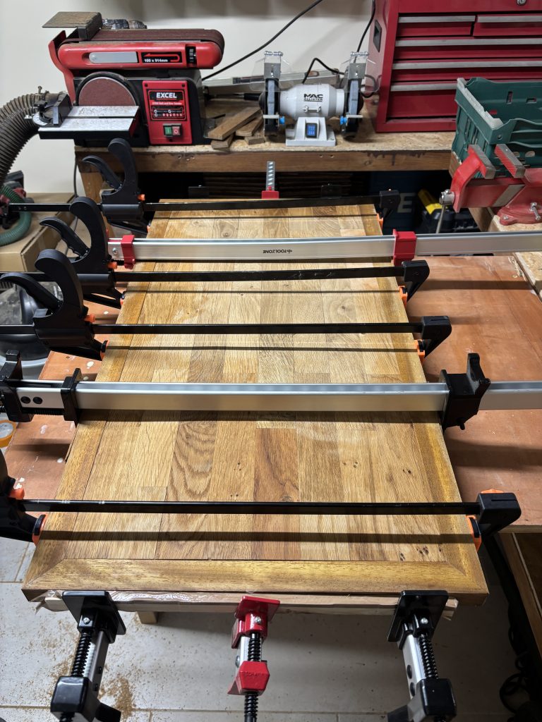 Handmade oak coffee table top clamped during assembly